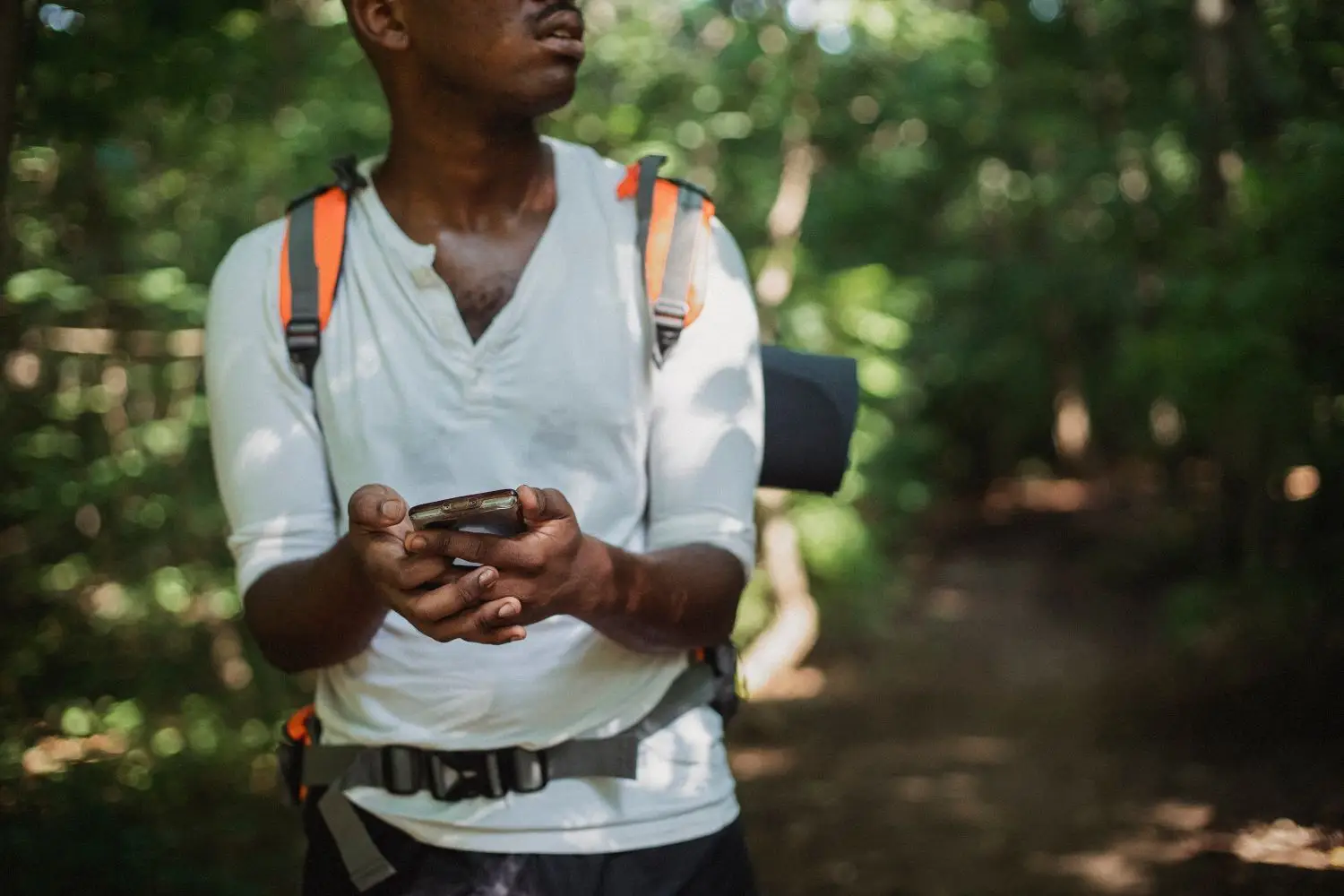 Participant holding a map while standing in woodland